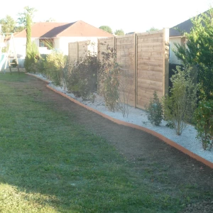 Élagueur 17 réalisant une pose méticuleuse de clôture décorative, embellissant les propriétés.